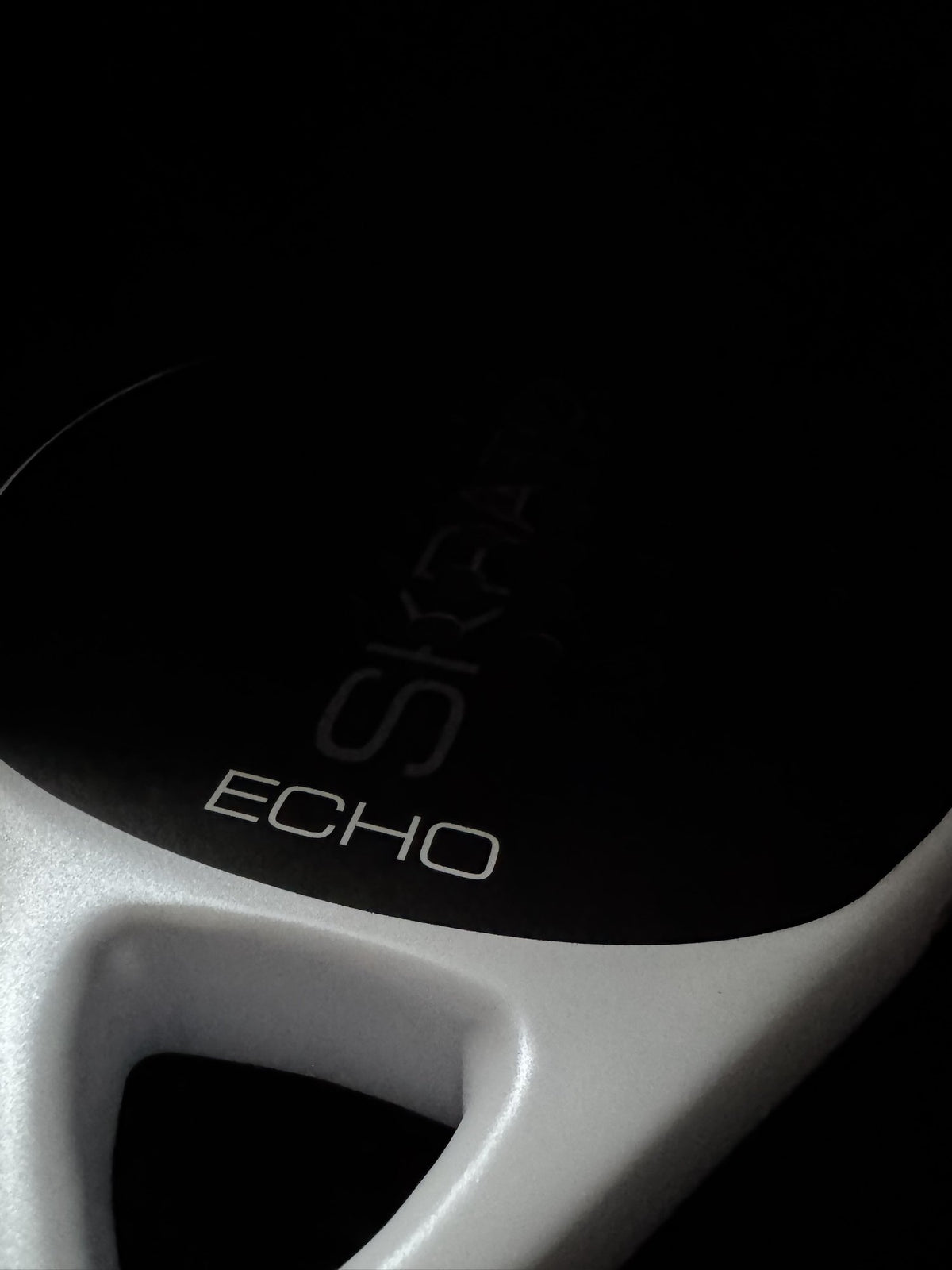 Close up studio shot of the SKRATCH ECHO padel racket showing the mist grey pearlescent bridge detail and ECHO model name.